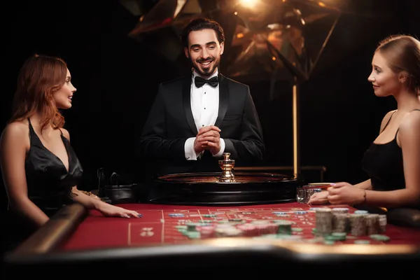 A woman in a luxurious green gown next to an ornate roulette wheel, capturing the upscale casino mood of BAJI200.